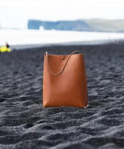 Skuldertaske i læder fra Ida Brink Leather: Anne med patina og klassisk hank på Reynisfjara-stranden i Island